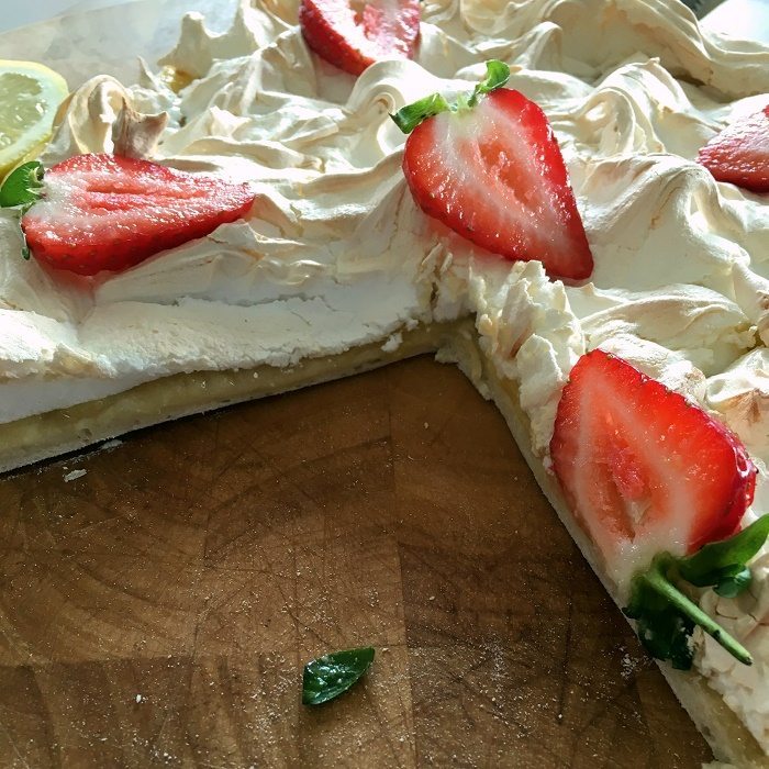 Lemon meringue pizza dotted with strawberry slices