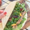 Fragrant slow roasted shoulder of lamb with a fresh mint chimichurri sauce and sweet sour pickled plums