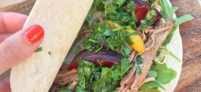 Fragrant slow roasted shoulder of lamb with a fresh mint chimichurri sauce and sweet sour pickled plums